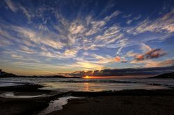 Tramonto con sfumature color arancione nel cielo nuvoloso alla baia di Finikas, isola di Syros, Grecia - © Lemonakis Antonis / Shutterstock.com