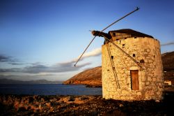 Il litorale di Kassos (Dodecaneso) al tramonto con il mulino a vento - Romantico, antico e "con quella faccia un po' così" come cantava Paolo Conte riferendosi a Genova, ...