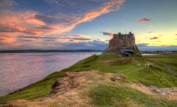 Tramonto sul castello di Lindisfarne, Inghilterra. Questo gioiello è il mix di un forte dell'artigliera Tudor e di una villa di campagna edoardiana. Le origini del maniero risalgono ...