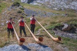 Tre suonatori di corno intrattengono gli ospiti di un lodge nel villaggio di Ovronnaz, Svizzera - © MoLarjung / Shutterstock.com