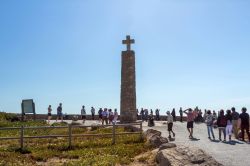 Turisti a Cabo da Roca nella frazione di Colares, Sintra, Portogallo. Nella terrazza che si affaccia sull'oceano Atlantico si trova anche un obelisco con una grande croce  - © ...