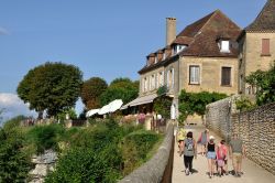 Turisti a passeggio nella via pedonale del centro di Domme, Dordogna, Francia - © Heliosphile / Shutterstock.com