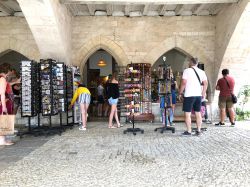 Turisti acquistano cartoline e braccialetti in un negozio di Monpazer, Dordogna, Francia - © Cmspic / Shutterstock.com