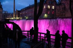 Turisti ammirano il paesaggio illuminato di Norrkoping, Svezia. Luci colorate abbelliscono la città durante il periodo natalizio - © Rolf_52 / Shutterstock.com