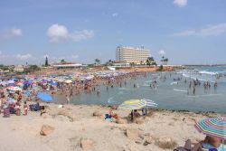 Turisti in spiaggia a Orihuela, Spagna. Senza correnti fredde, l'acqua del mare che lambisce la Costa Blanca mantiene tutto l'anno una temperatura piuttosto calda che rende questa località ...