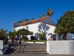 Turisti in visita a Puerto de la Cruz in una giornata di sole, Tenerife, Spagna. Sullo sfondo, una chiesetta intonacata di bianco - © Kristyna Henkeova / Shutterstock.com