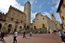 Turisti in visita al centro storico di San Gimignano, Siena, Toscana. Sono milioni le persone che ogni anno, in qualsiasi stagione, visitano questa bella città medievale alle porte di ...