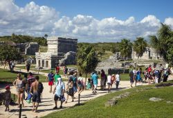 Turisti in visita al sito archeologico di Tulum, Messico. Questo sito deve la sua popolarità alla posizione in cui si trova: fu la prima città maya ad essere avvistata dagli spagnoli ...