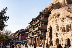 Turisti in visita alle Yungang Grottoes di Datong, Cina. Sito Unesco, accoglie alcune delle statue buddhiste più belle di tutta la Cina - © Giusparta / Shutterstock.com