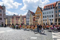 Turisti nei locali all'aperto di Rathausplatz nel centro di Augusta (Germania) - © muratart / Shutterstock.com