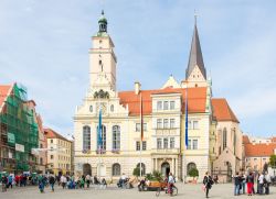 Turisti nella piazza su cui si affaccia il Municipio di Ingolstadt, Germania. Questa bella fotografia è stata scattata da Moritzstrasse: l'Altes Rathaus, risalente al XIV° secolo, ...