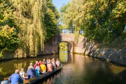 Turisti su una barca in un canale della cittadina di Naarden, Paesi Bassi. Un suggestivo scorcio autunnale del paesaggio naturale in cui si trova questa località le cui tracce risalgono ...