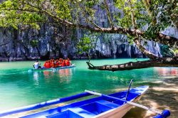 Turisti su una barca nei pressi della grotta del fiume Underground, Palawan, Filippine.  Si tratta di una delle nuove sette meraviglie del mondo della natura - © Tetyana Dotsenko / ...