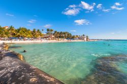 Turisti sulla celebre spiaggia Playa del Norte sull'Isla Mujeres, Messico.  Questa spiaggia, come le altre delr esto, è circondata da un mare di rara bellezza con parchi marini ...