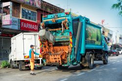 Un addetto del Comune raccoglie i rifiuti nel camion della nettezza urbana in Johor Bahru Street, Malesia - © tristan tan / Shutterstock.com