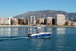 Un aliscafo si allontana dal porto di Fuengirola, provincia di Malaga, Spagna. Sullo sfondo, edifici e spiagge di questa apprezzata meta turistica dell'Andalusia - © Arena Photo UK ...