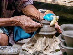 Un artigiano thailandese modella un vaso di ceramica a Ko Kret, Nonthaburi.

