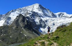 Un atleta percorre correndo gli sterrati fra le montagne di Arolla, Svizzera, in una giornata di sole.

