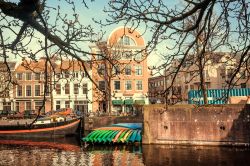 Un canale a L'Aia con barche e canoe ormeggiate (Olanda). Sullo sfondo, le tipiche abitazioni della cittadina olandese - © Radiokafka / Shutterstock.com
