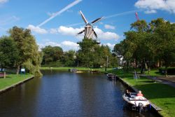 Un canale del centro storico di Leiden con parco e mulino, Olanda. E' uno dei tipici scorci paesaggistici di questa bella cittadina olandese.


