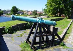 Un cannone della Christiansholm Fortress a Kristiansand, Norvegia, con il paesaggio cittadino sullo sfondo. Ad impreziosire questa fortificazione tozza e circolare costruita nel 1672 è ...