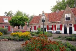 Un cortile fiorito a Naaldwijk, Olanda. Da notare anche gli infissi rossi in legno che impreziosiscono le facciate delle casette.
