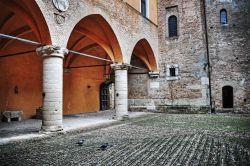 Un cortile rustico nel centro storico di Gradara, Italia. Porticato e decorazioni impreziosiscono questo bello spazio all'aperto all'interno di un edificio del borgo marchigiano
