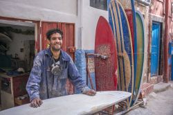 Un giovane artigiano costruisce tavole da surf in una bottega del villaggio di Taghazout, Marocco - © Salvador Aznar / Shutterstock.com