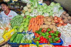 Un giovane venditore di frutta e verdura fresca in un negozio del mercato centrale di Palawan, isola di palawan, Filippine - © Michael Wels / Shutterstock.com