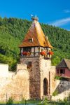 Un grazioso scorcio del villaggio di Chatenois, Alsazia (Francia): un'antica costruzione a torre con le cicogne sul tetto.
