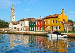 Un imbarcadero di Burano, con veduta della Chiesa di San Martino - la Chiesa di San Martino è l'unico edificio religioso della piccola isola di Burano. Costruita nel 1500, questa ...