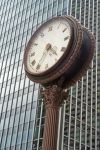 Un orologio su una strada del centro di Seattle, stato di Washington. Sullo sfondo, un grattacielo di vetro.



