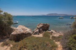 Un paesaggio selvaggio dell'isola di Schinoussa (Grecia): sullo sfondo, barche attraccate lungo la costa delle Cicladi.
