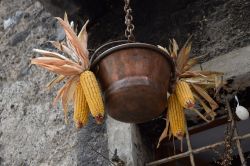 Un paiolo in rame con pannocchie nel borgo di Rango, Trentino Alto Adige.
