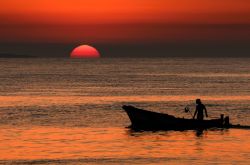 Un pescatore al tramonto sul mare di Terrasini in Sicilia