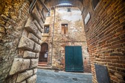 Un piccolo arco nel centro storico di Montepulciano, Toscana, Italia. Un pittoresco scorcio fotografico fra le antiche vie della città.

