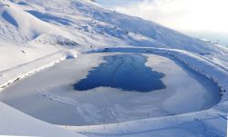 Un pittoresco lago ghiacciato a Rothorn nel villaggio svizzero di Lenzerheide. Siamo nel Canton Grigioni, in un'importante stazione sciistica. 
