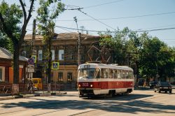 Un pittoresco scorcio di Samara, Russia, con vecchie case in legno e il tram numero 3 intento a transitare in una strada cittadina.

