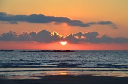 Un pittoresco tramonto su una spiaggia di Viana do Castelo, Portogallo. I colori del cielo si riflettono sull'acqua dell'oceano Atlantico.



