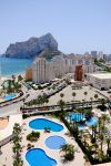 Un resort con piscina a Calpe, Spagna. Sullo sfondo, grattecieli e il Penon de Ifach - © AFS / Shutterstock.com