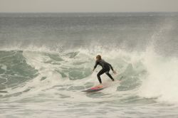 Un surfista cavalca le onde a Bells Beach, Torquay, Australia. Questa rinomata spiaggia da surf, situata a 100 km da Melbourne, nei pressi di Torquay, si trova sulla Great Ocean Road.
