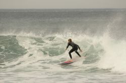 Un surfista cavalca le onde a Bells Beach, Torquay, Australia. Questa rinomata spiaggia da surf, situata a 100 km da Melbourne, nei pressi di Torquay, si trova sulla Great Ocean Road.
