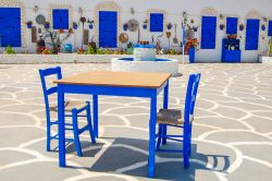 Un tavolo con sedie nella piazza del villaggio di Protaras, isola di Cipro. Questa località è caratterizzata dalla tradizionale architettura greca.

