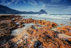 Un tratto di costa rocciosa a Capo di Milazzo, Sicilia. Capo di Milazzo si trova nel territorio in provincia di Messina; è il capo con cui si conclude a ovest il Golfo di Milazzo e inizia ...