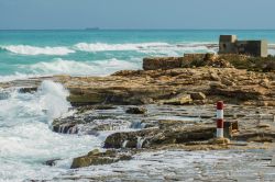 Un tratto di costa rocciosa nei pressi di Marsascala, isola di Malta, lambita dalle acque blu del Mediterraneo.


