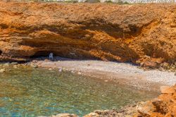 Un tratto di costa rocciosa sull'isola di Syros, arcipelago delle Cicladi, Grecia. Rocce di colore rossastro sono disposte in forma circolare.



