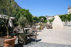 Un turista seduto ad un tavolino in Place d'Assas a Nimes, Francia. Siamo nella regione dell'Occitania, dipartimendo del Gard di cui Nimes è considerata la capitale - © vvoe ...