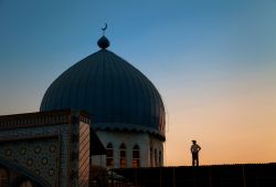 Un uomo osserva il tetto della moschea Haji Yakub a Dushanbe, Tagikistan, al calar del sole - © Yury Birukov / Shutterstock.com