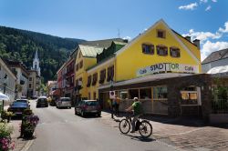 Un uomo su una bici elettrica di fronte ad un caffé nel centro di Schladming, Austria - © josefkubes / Shutterstock.com