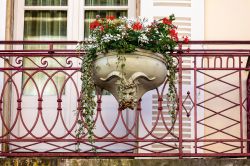 Un vaso  di ceramica con fiori colorati in un balcone di Beaune, Francia - © Nigel Jarvis / Shutterstock.com